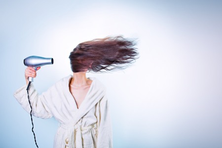 Young woman blow drying hair